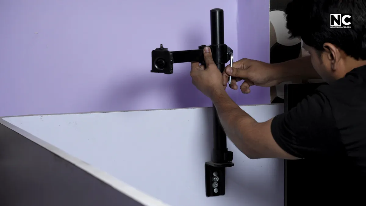 Monitor arm assembled and mounted to the edge of a desk