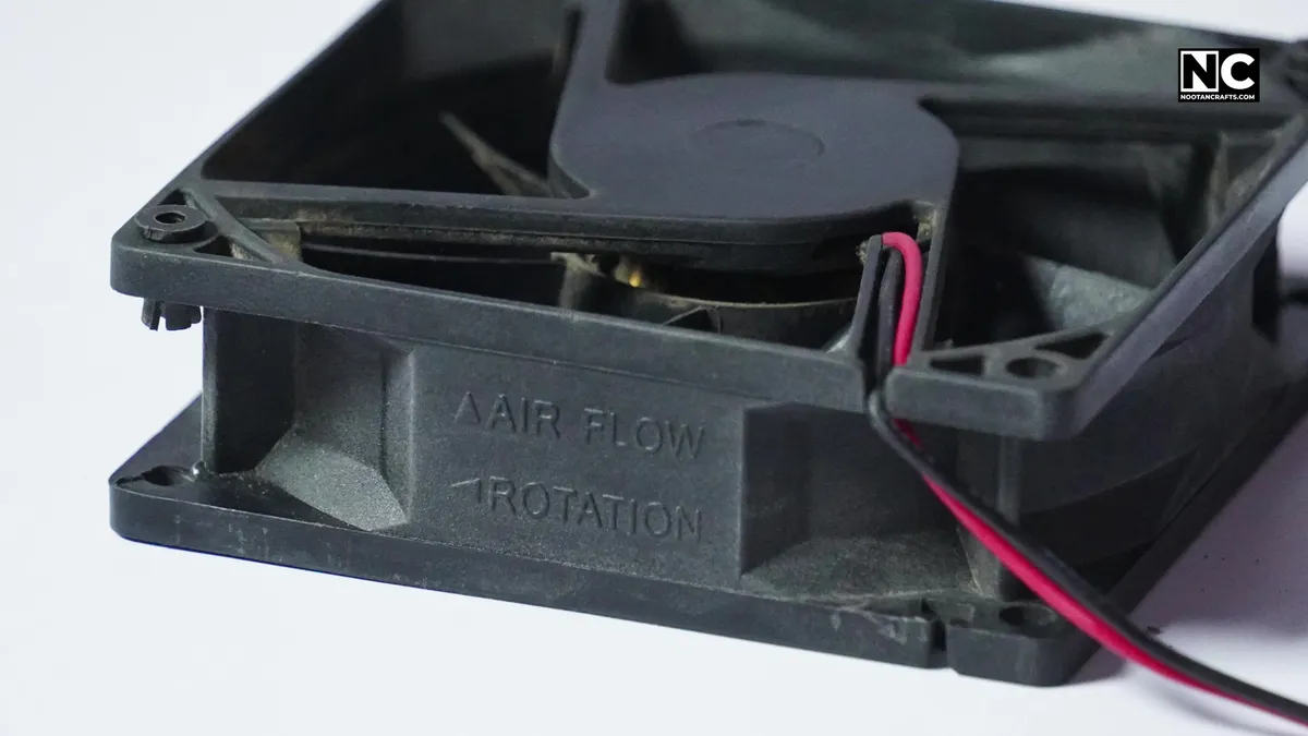 Molded arrows on the side of a case fan indicating airflow and blade rotation direction