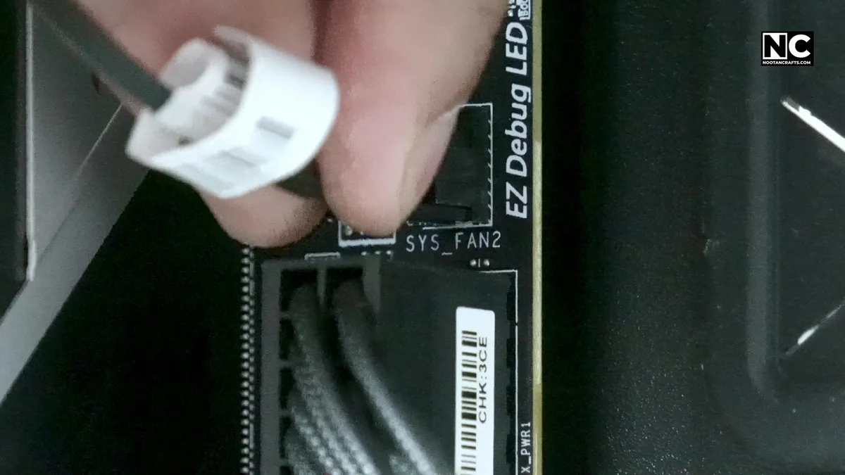 Connecting a four-pin fan cable to a SYS_FAN header on the motherboard