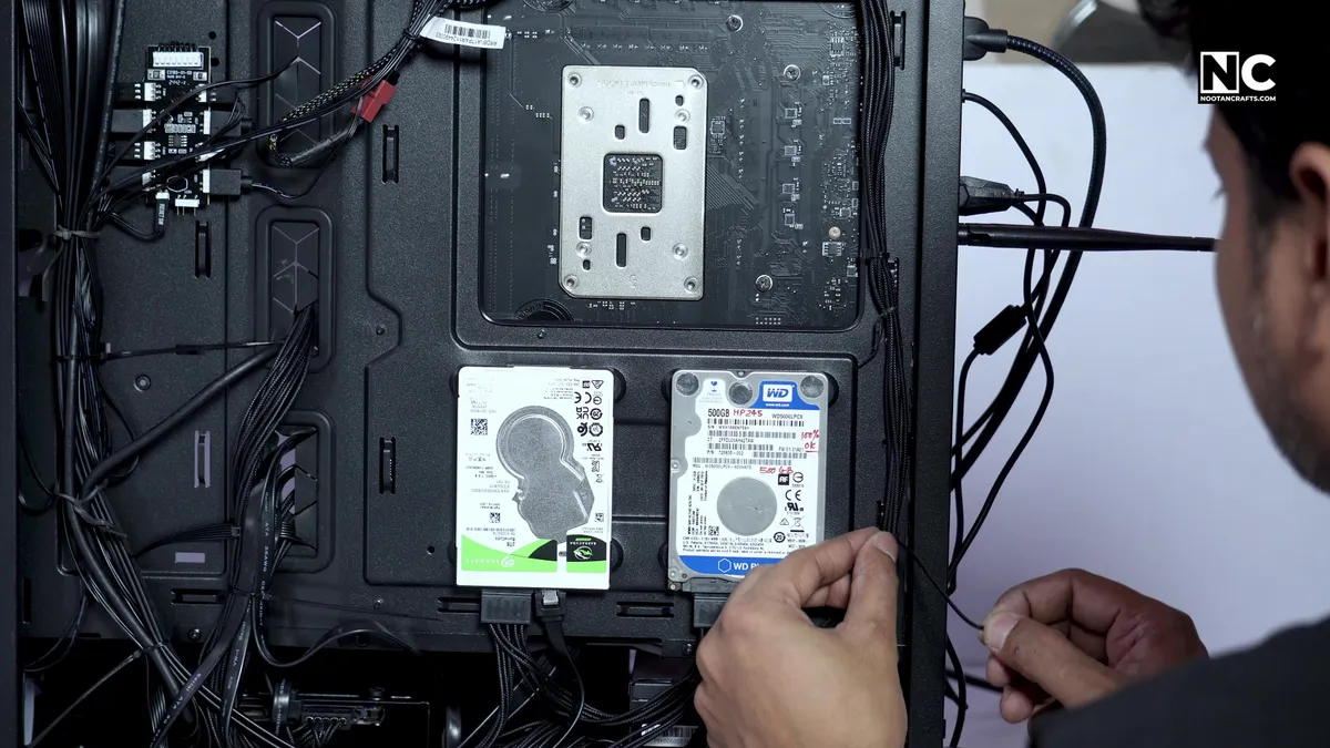 Using a zip tie to secure fan cables behind the motherboard tray